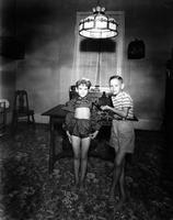 Boy and girl with chicken in room