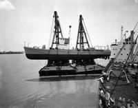 Derrick Barge loading tugboat onto freighter