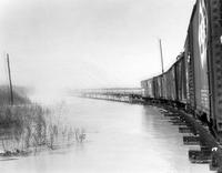 Railroad cars on trestle over river