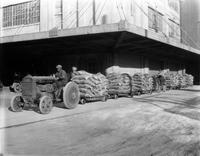 Tractor pulling carts with sacks