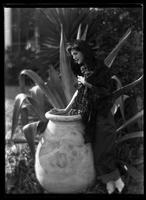 Girl wrapped in lace next to an urn and a century plant