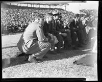 Men Seated on the Sideline During a Football Game 