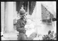 Man in Hat Holding a Baby