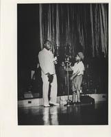 Louis Armstrong with young boy on stage