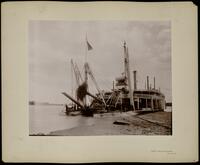 Commissioned C.R. Suter moored riverside with snag being pulled aboard, camera looks amid ships