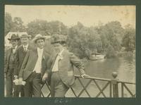 Four men posing for the camera on a bridge crossing the Amite River.