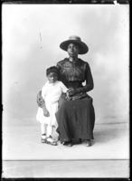 Studio portrait of seated African American woman and young girl.