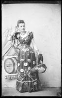 Woman with fish, crabs, and the name Postlewaithe & Chase on costume is holding a sugar-cured ham.
