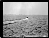 Men in boat heading across large body of water
