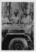 Two men and two women standing at front of military vehicle U.S.A 2080710