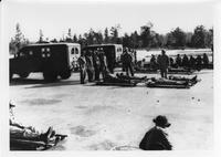 Soldiers with ambulances and men on stretchers