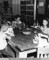 Children reading at the grand opening of the Catahoula parish library in Harrisonburg Louisiana in 1949