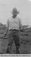 Man holding a dibble in Louisiana in the 1920s