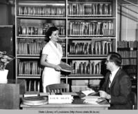 Librarian Vivian Cazayoux helping patrons in Baton Rouge Louisiana circa 1957
