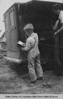 Little boy browses book from bookmobile in Winn Parish Louisiana in 1938