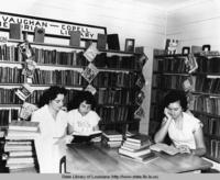 Young women reading at a table inside the Vaughan-Copel Memorial Library in Kaplan Louisiana