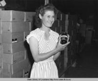 Woman displaying jar of Colonial pure strawberry preserves in Louisiana in the 1940s