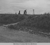 People walking along railroad tracks on top of levee at Baton Rouge Louisiana in 1945