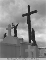 Religious sculputure figures atop vaults and head stones possibly in the Metairie cemetery in Metairie Louisiana circa 1970s