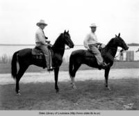 Tom Watson and R.L. James ride horses near river in the 1940s