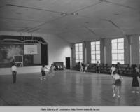 Girls playing basketball in Dutchtown Louisiana high school gymnasium in the 1930s