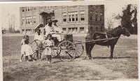 Women and children with a horse-drawn buggy