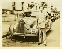 Huey P. Long portrait next to parked DeSoto in the District of Columbia.